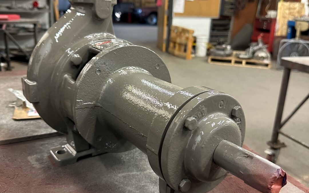 A Worthington D814 3x2x5T industrial pump sitting on a metal table. The pump has a flange on the bottom for connection to pipes.